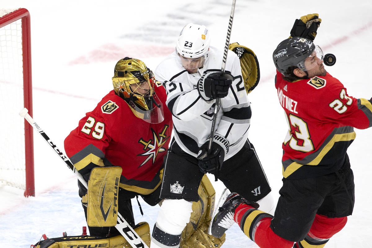 Golden Knights defenseman Alec Martinez (23) takes a puck to the face while defending as Kings ...