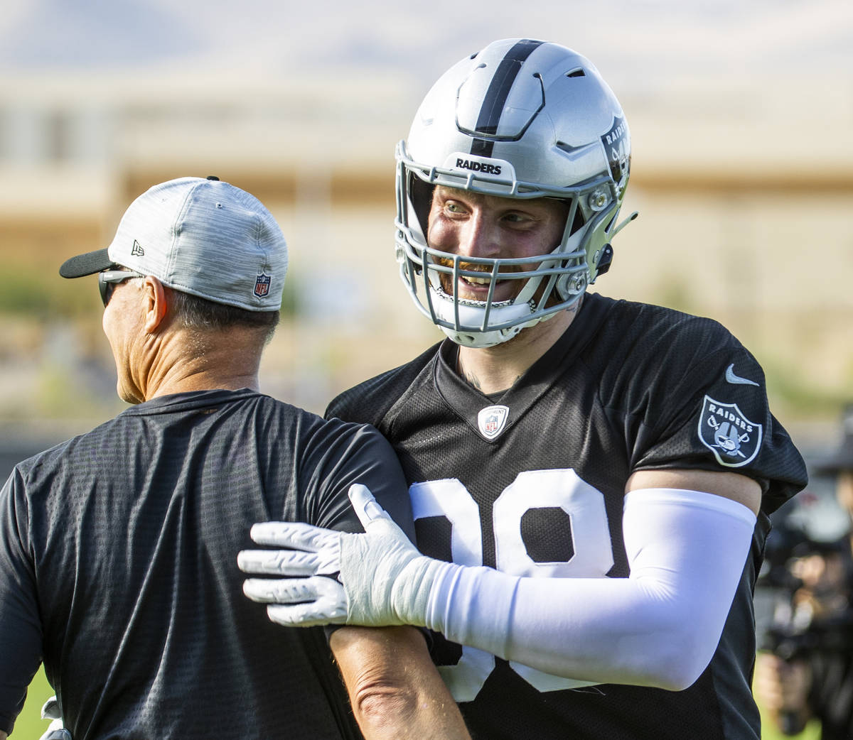 Raiders defensive end Maxx Crosby (98) shares a greeting during the Raiders training camp at th ...