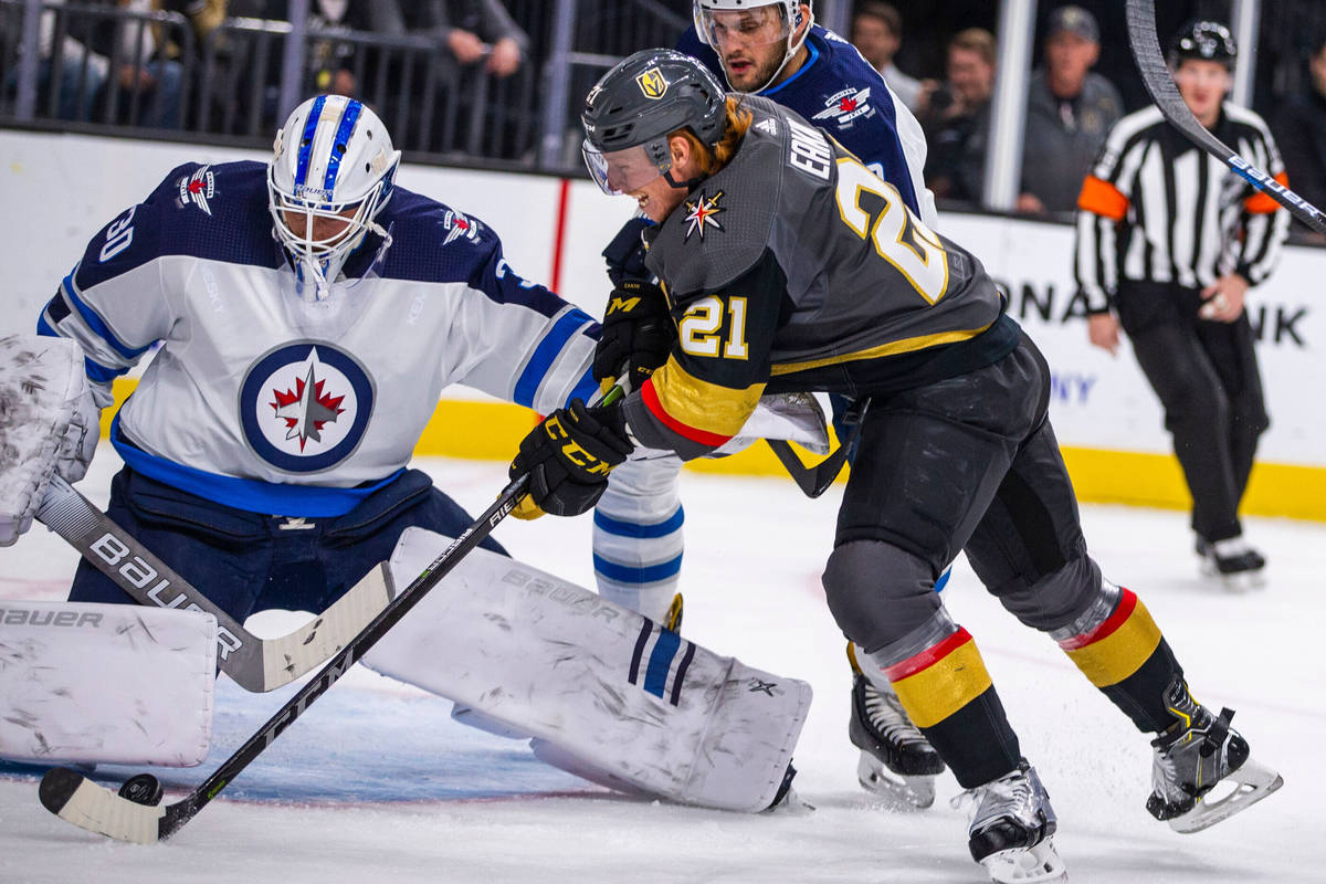 Winnipeg Jets goaltender Laurent Brossoit (30) gets a pad on a shot by Vegas Golden Knights cen ...