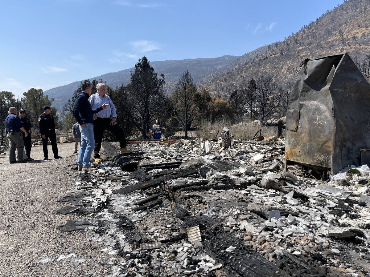 Govs. Newsom and Sisolak confer and look over the remains of a home in Gardnerville, NV, destro ...