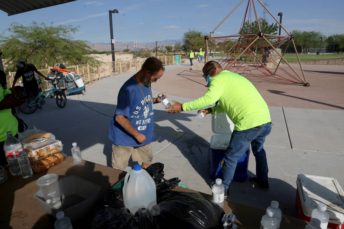 HELP of Southern Nevada Director of Crisis Teams Louis Lacey, right, gives water to Carl Nickel ...