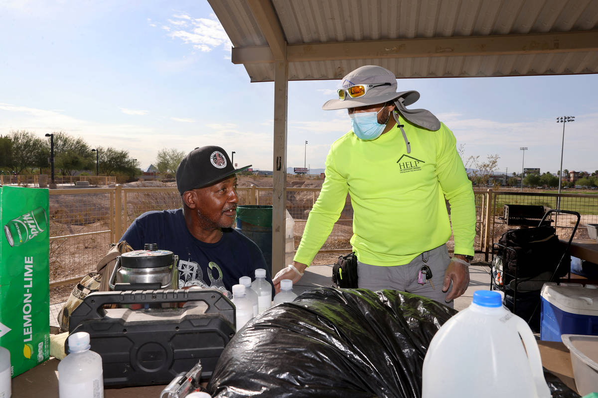 HELP of Southern Nevada outreach worker Abdul Hamdard gives water to Earl Howard, 62, during an ...