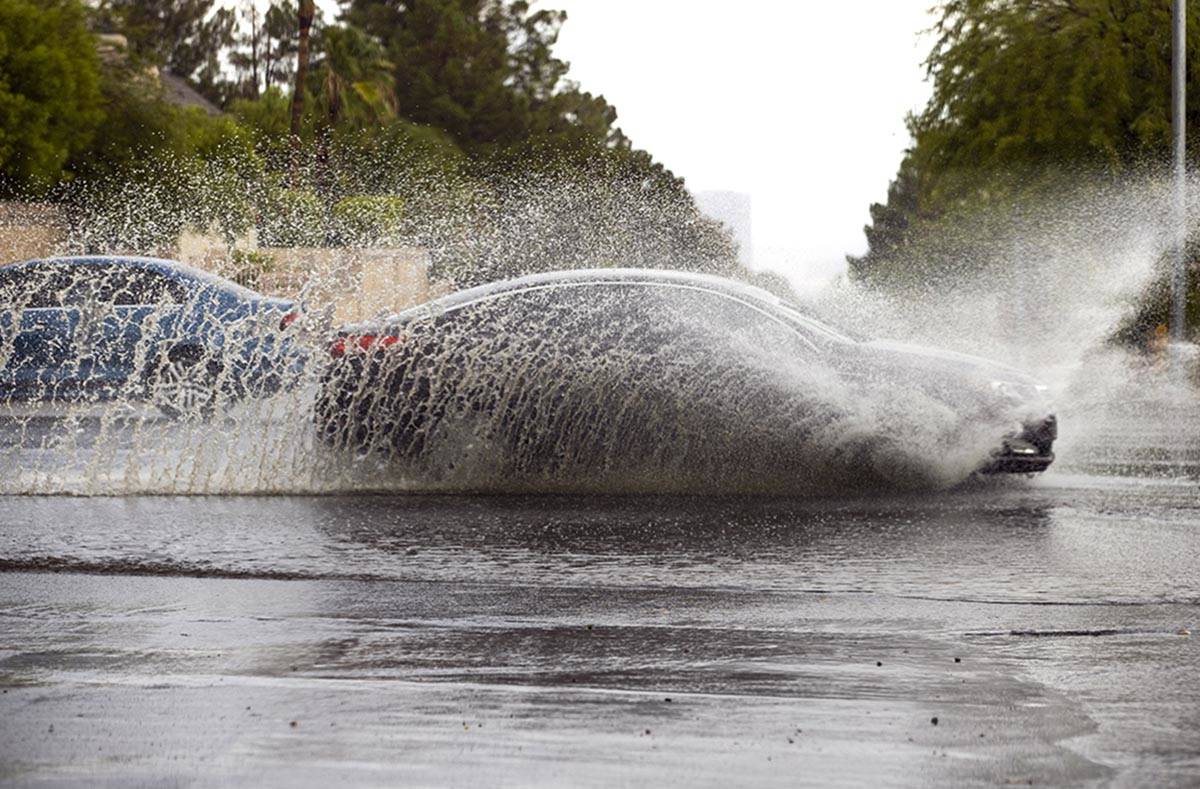 A car drives through high water on South Buffalo Drive at West Darby Avenue as rain continues a ...