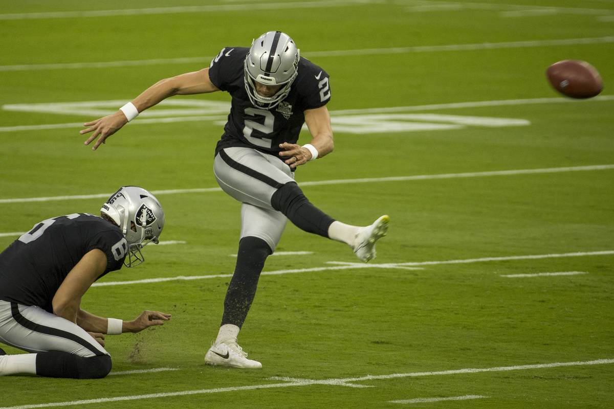 Las Vegas Raiders punter AJ Cole (6, left) holds the ball as place kicker Daniel Carlson (2) ge ...