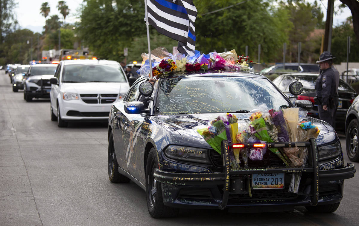 Nevada Highway Patrol trooper Micah May's squad car is decorated with signatures, flowers and f ...