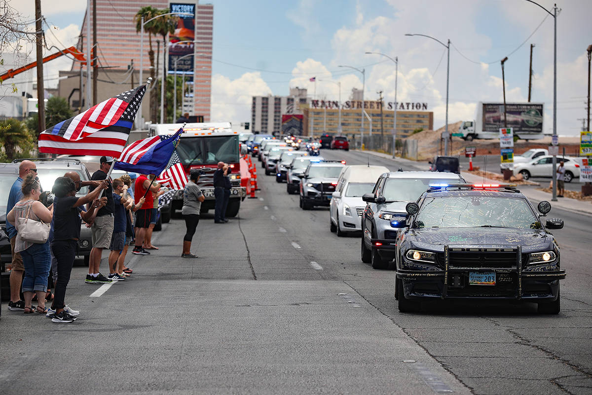 Bystanders watch a procession moving the body of slain Nevada Highway Patrol Trooper Micah May ...