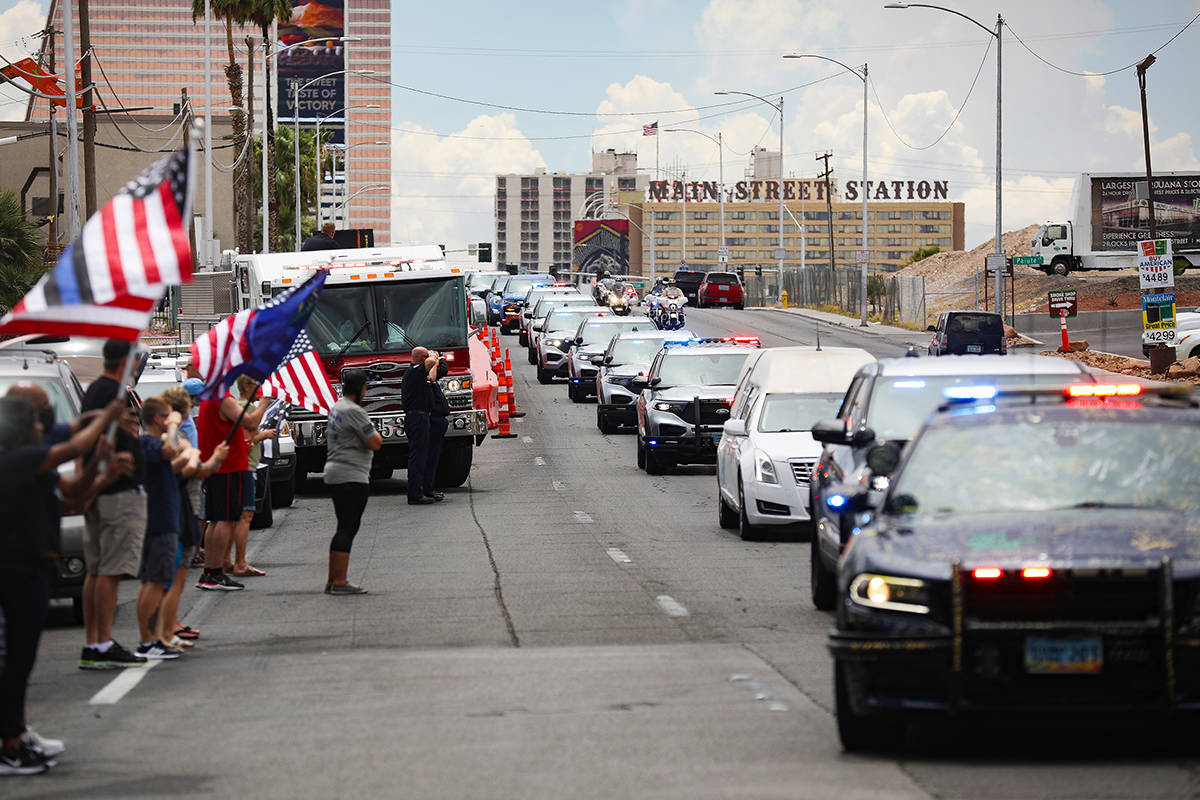 Bystanders watch a procession moving the body of slain Nevada Highway Patrol Trooper Micah May ...