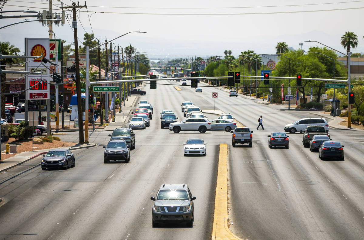 A pedestrian and vehicles travel through the intersection of North Lamb Boulevard and East Wash ...