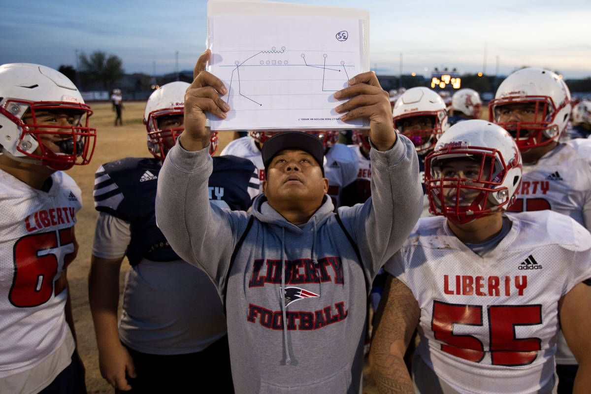 Liberty High School coach Al Tucay holds up a play for the team during football practice at Lib ...