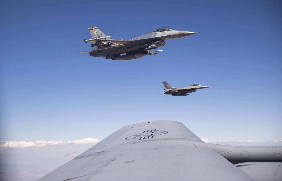 Two F-16s fly alongside a KC-135 Stratotanker as it refuels planes around the Nevada Test and T ...