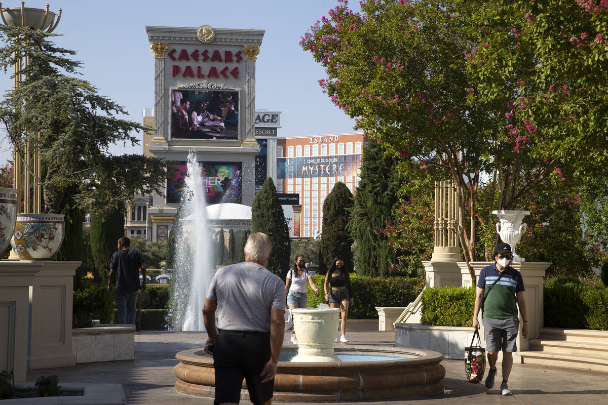 Visitors stroll on the Caesars Palace property on Wednesday, Aug. 4, 2021, on the Las Vegas Str ...
