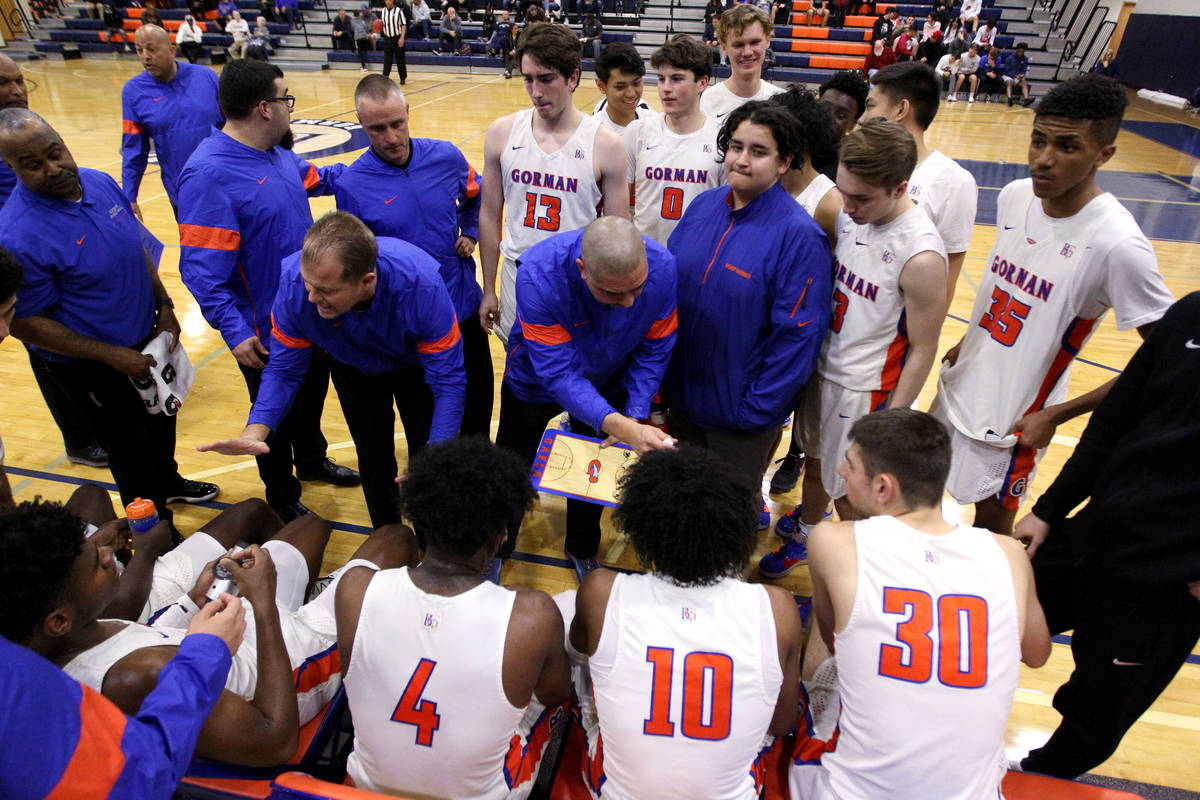 Bishop Gorman coaches talk to their players before the start of the fourt quarter of their bask ...