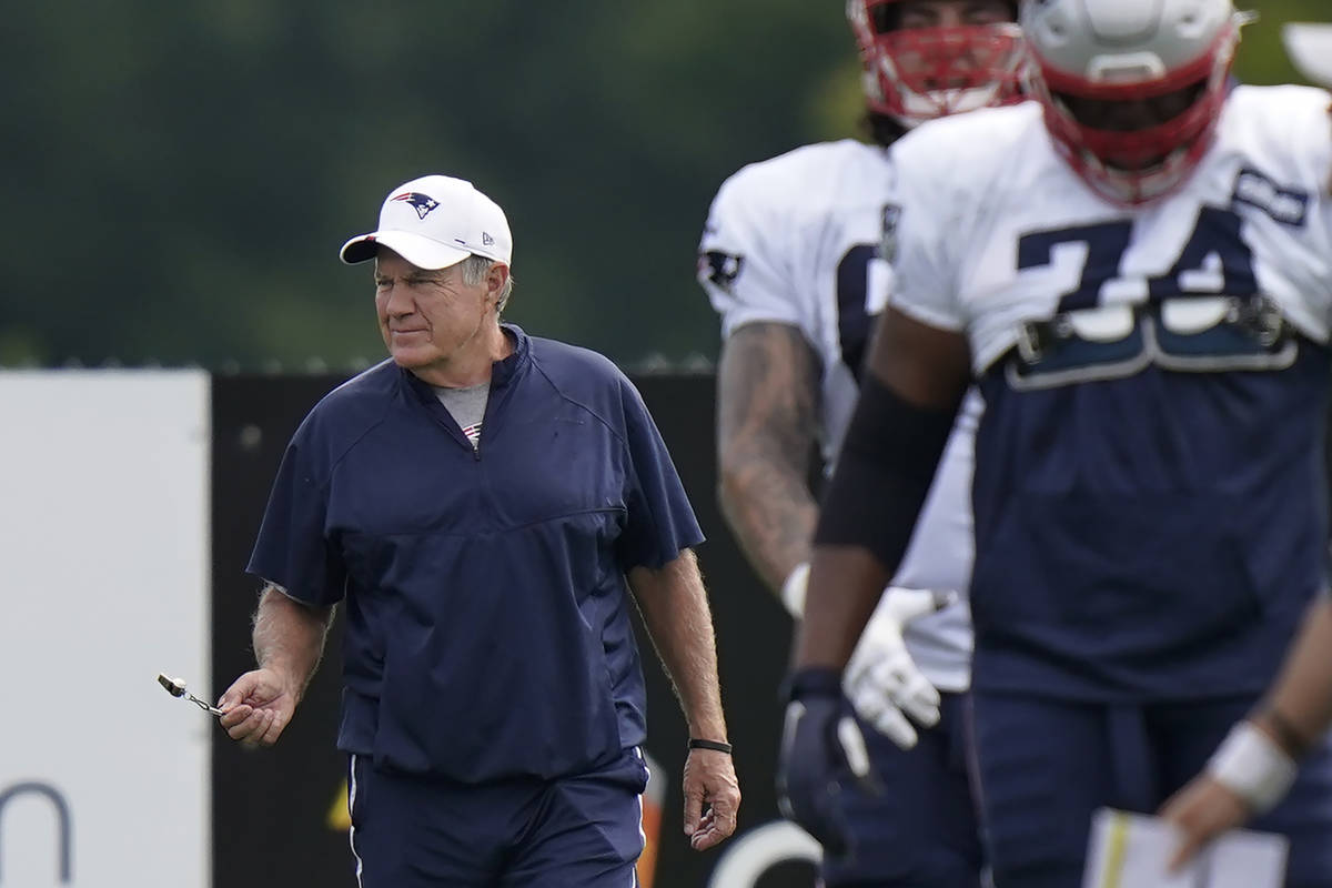 New England Patriots head coach Bill Belichick, left, walks on the field near players during an ...