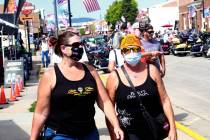 Women walk during opening day of the 80th annual Sturgis Motorcycle Rally in Sturgis, S.D., in ...