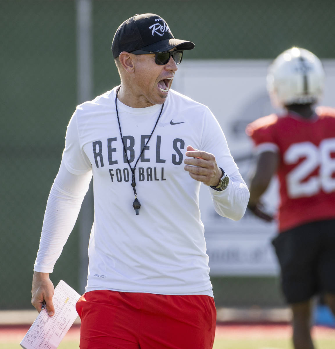 UNLV Head Coach Marcus Arroyo yells some encouragement to his players during a drill in footbal ...