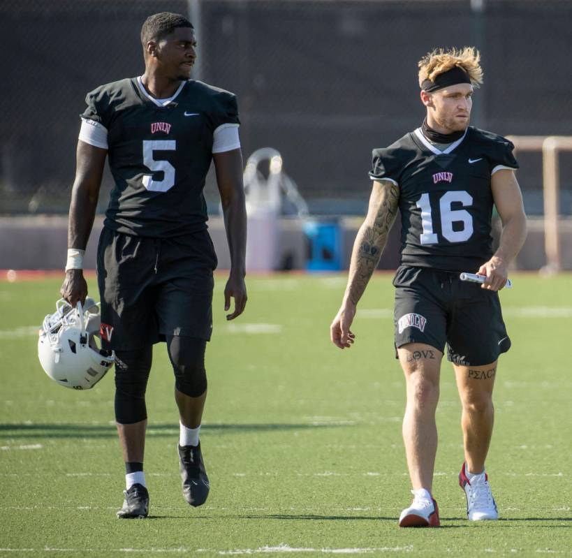 UNLV quarterbacks Justin Rogers (5) and Tate Martell (16) walk up the field during football tea ...