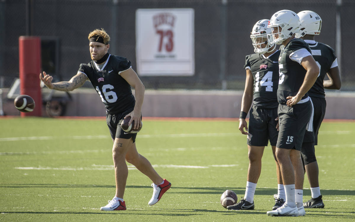 UNLV quarterback Tate Martell (16, left) tosses in a ball to a teammate as other quarterbacks l ...