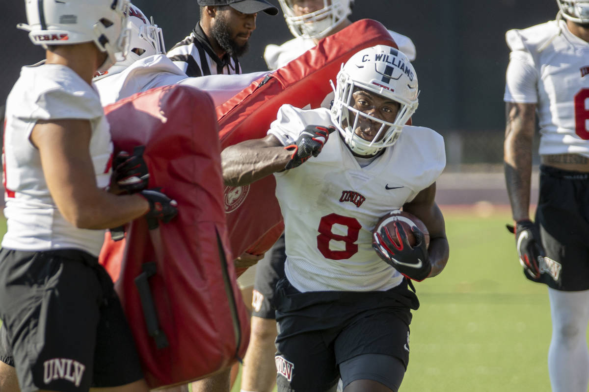 UNLV running back Charles Williams (8) hits a pad on a drill during football team practice at R ...