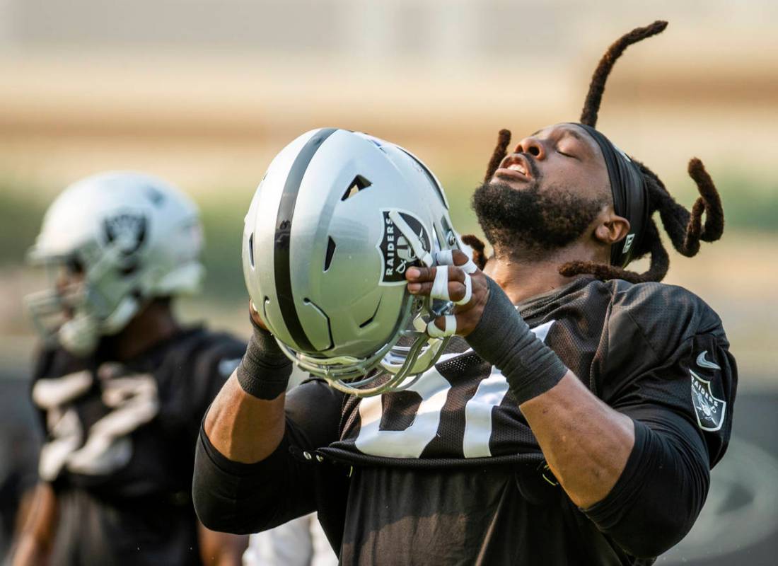 Raiders defensive tackle Gerald McCoy (61) throws his hair back to put his helmet on during pra ...