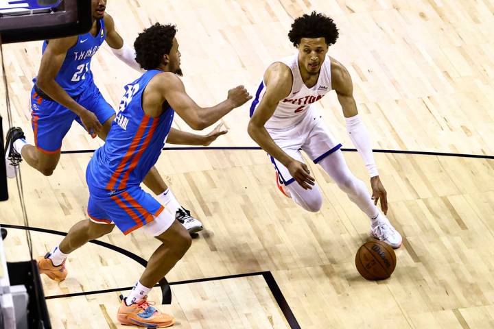 Detroit's Cade Cunningham, right, drives the ball around Oklahoma City's Jeremiah Robinson-Earl ...