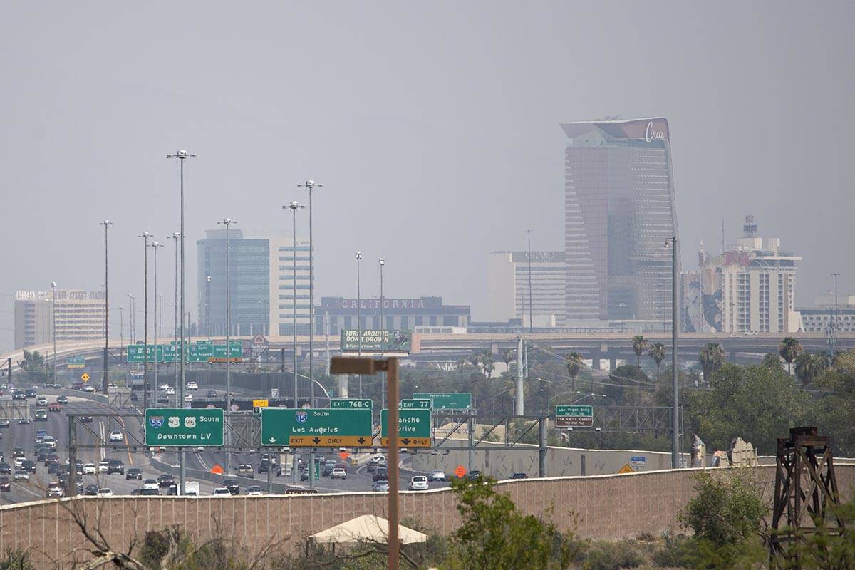 Traffic moves along U.S. 95 and Interstate 15 while smoky skies cloud the skyline on Saturday, ...