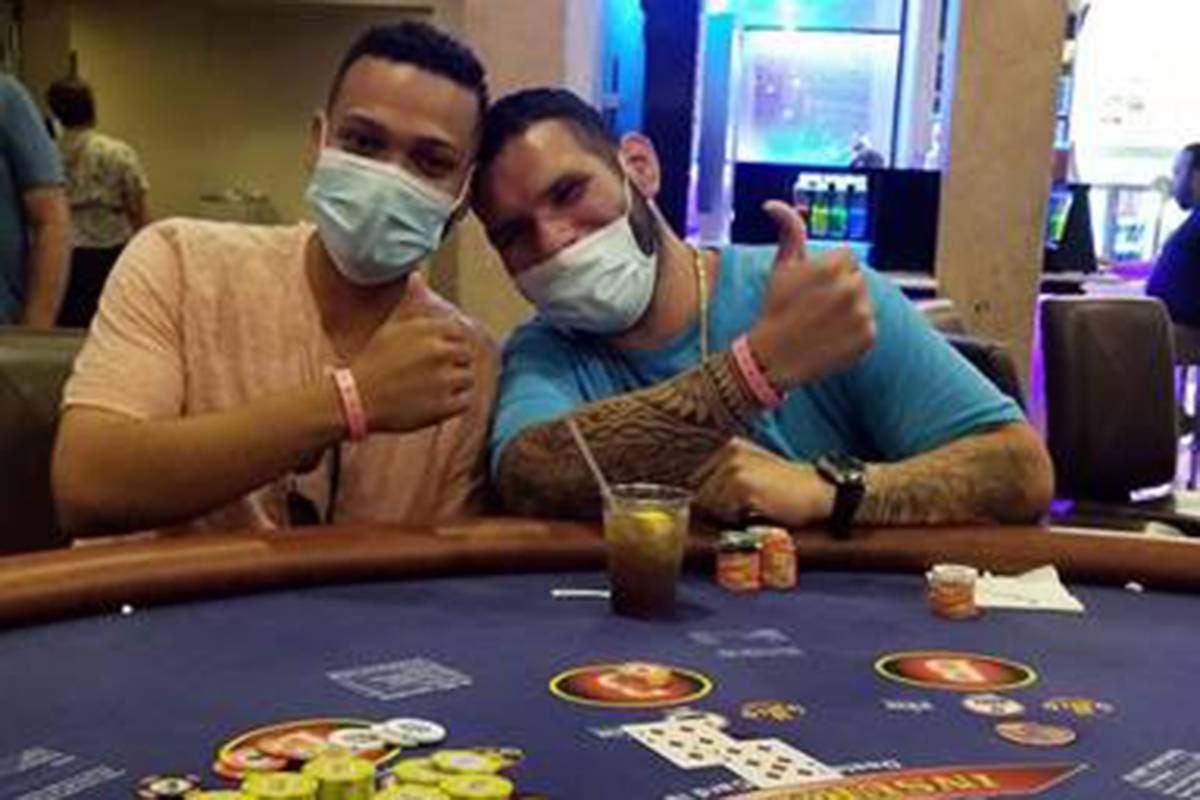 Brian Rodriguez, left, celebrates with a friend after hitting a jackpot at Bally's. (Caesars En ...
