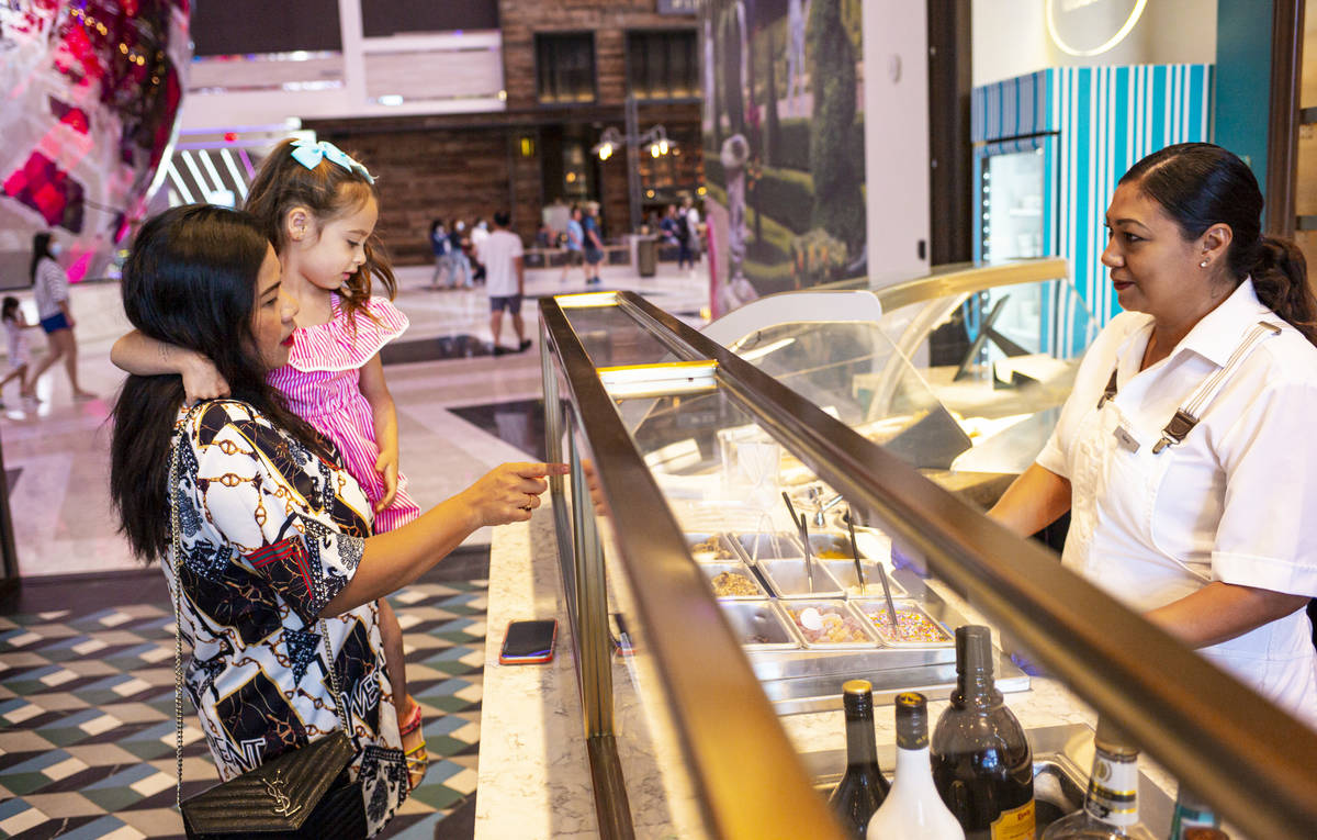 Fountain worker Maria Casian, right, adds toppings to ice cream for Jayne Hirschi, of Las Vegas ...