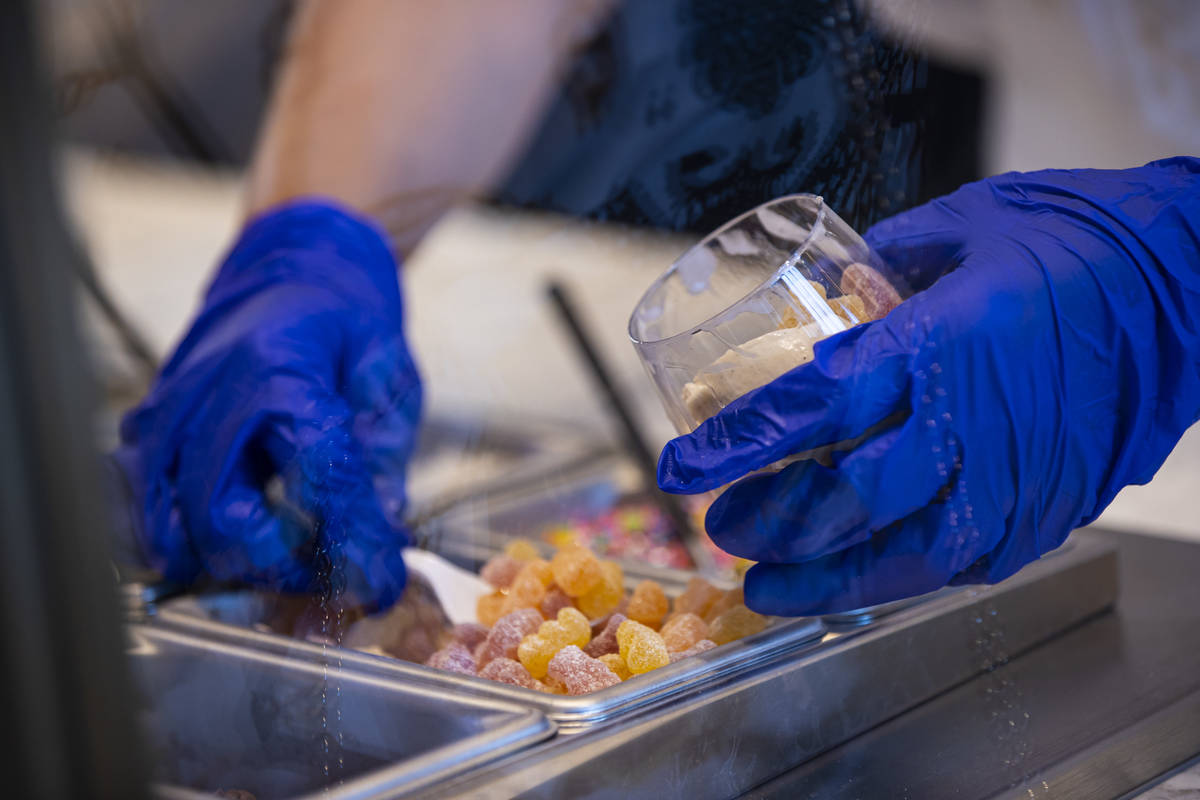 Fountain worker Maria Casian adds toppings to ice cream at Craig's Vegan in The District at Res ...