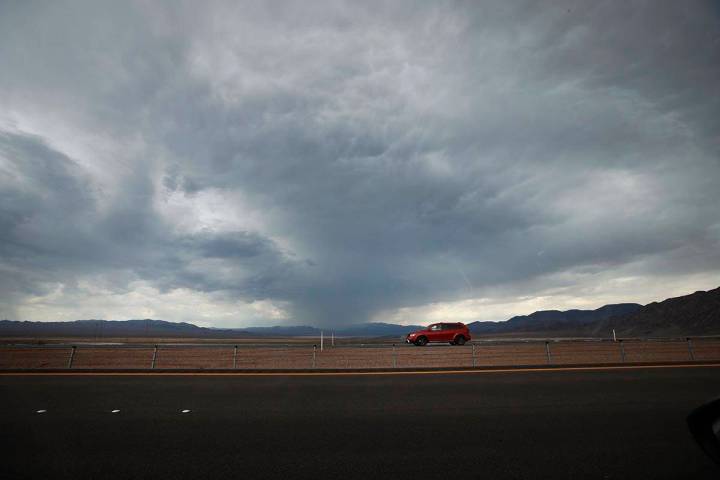 A car drives on U.S. Route 93 around Boulder City, Wednesday, July 21, 2021, when dark clouds d ...