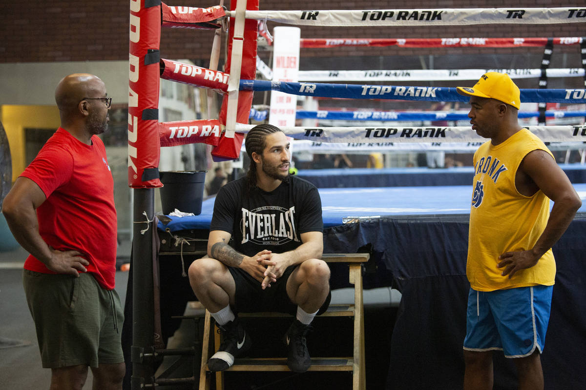 Boxer Nico Ali Walsh, center, speaks with his athletic performance training coach B.B. Hudson, ...