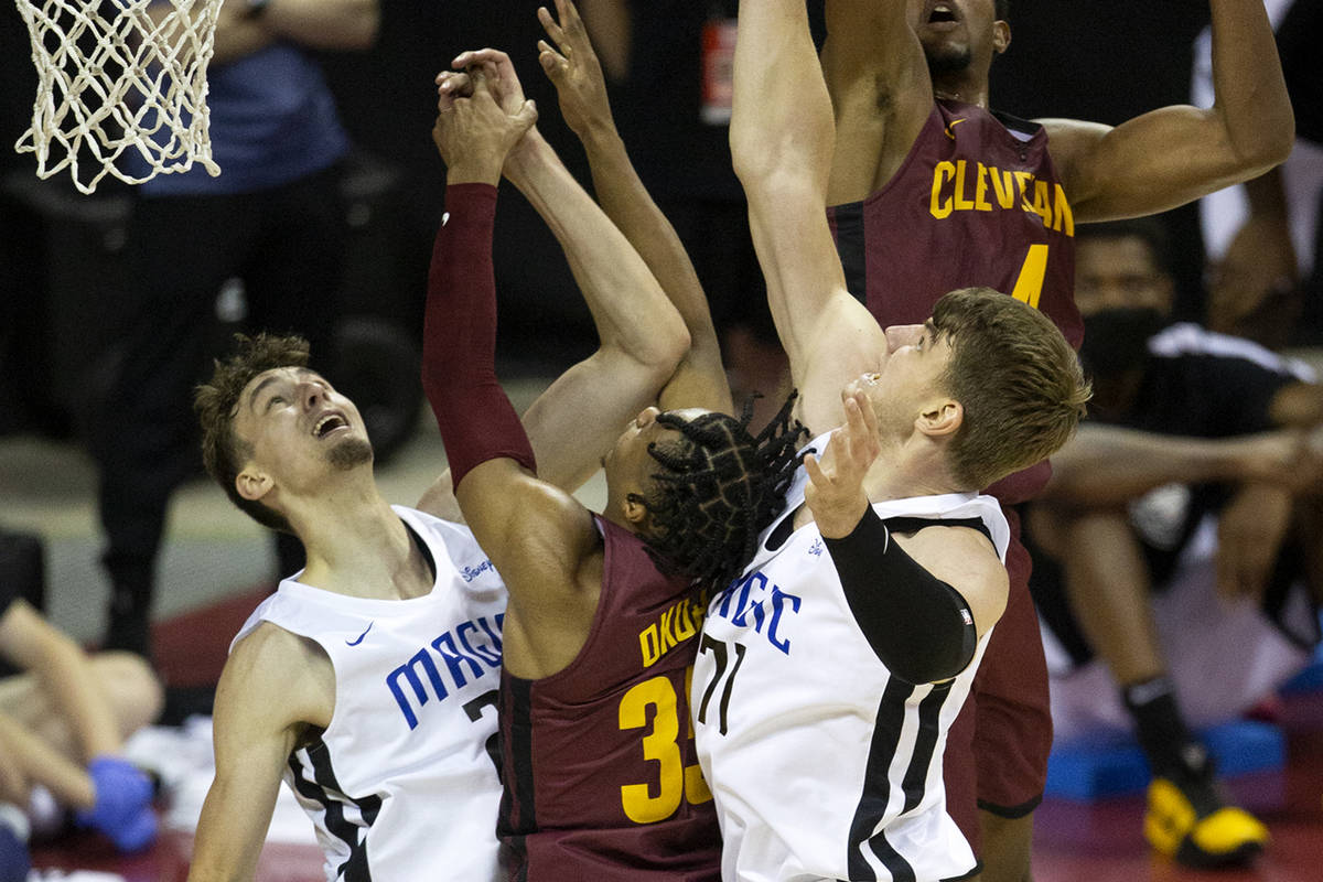 Cleveland Cavaliers forward Evan Mobley (4) and guard Isaac Okoro (35) jump to block a shot by ...