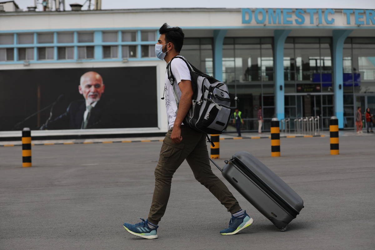 A passenger walks to the departures terminal of Hamid Karzai International Airport, in Kabul, A ...
