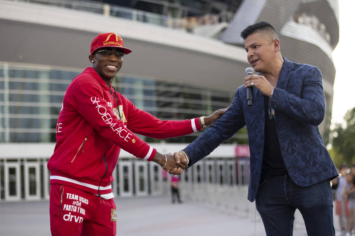 Yordenis Ugas, left, is welcomed to the stage by host Ray Flores during a boxing press conferen ...