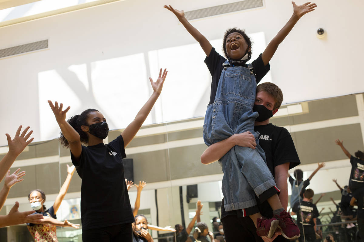 Koston Pabon lifts Micah Marino, who plays Andie, during a rehearsal for Broadway in the HOOD's ...