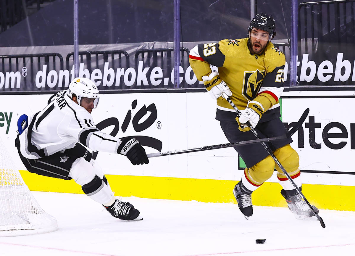 Golden Knights defenseman Alec Martinez (23) skates with the puck under pressure from Los Angel ...