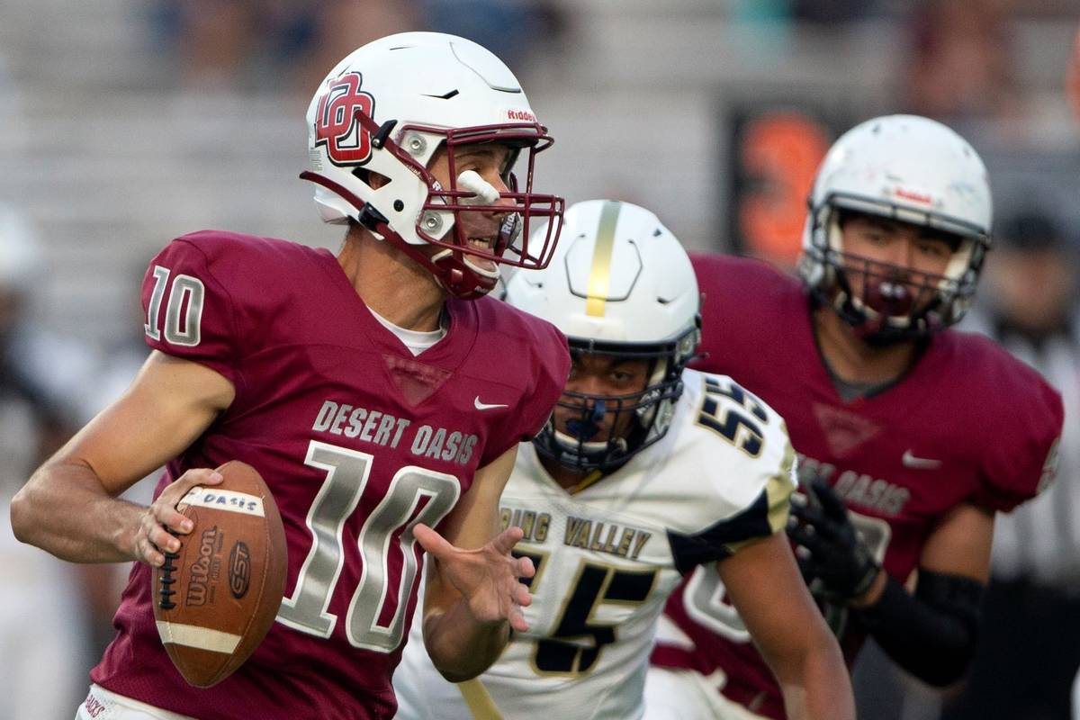 Desert Oasis quarterback Tyler Stott (10) looks to pass while Spring Valley offensive lineman T ...