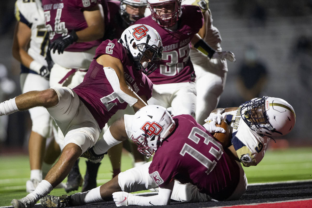 Spring Valley running back Jaden Linzie (9) scores a touchdown while falling over Desert Oasis ...