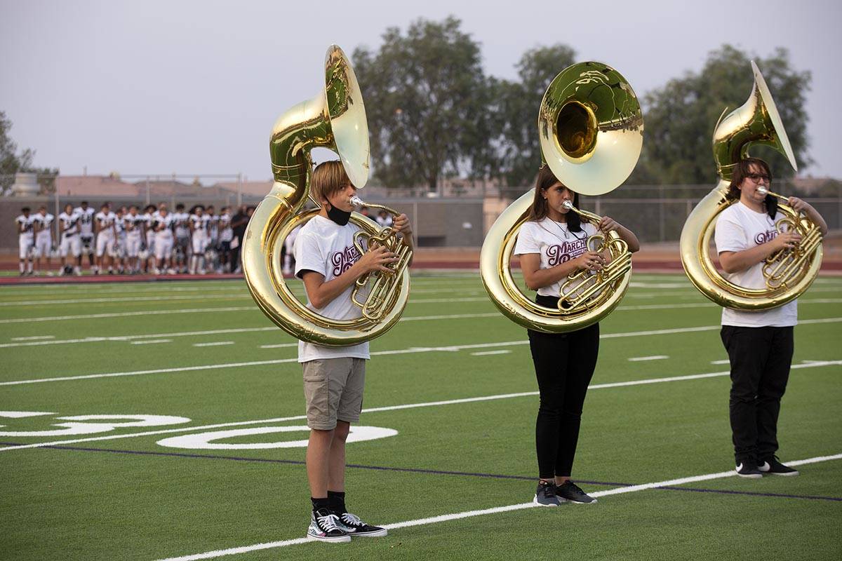 Tuba players with the Desert Oasis marching band play ahead of a high school football game agai ...
