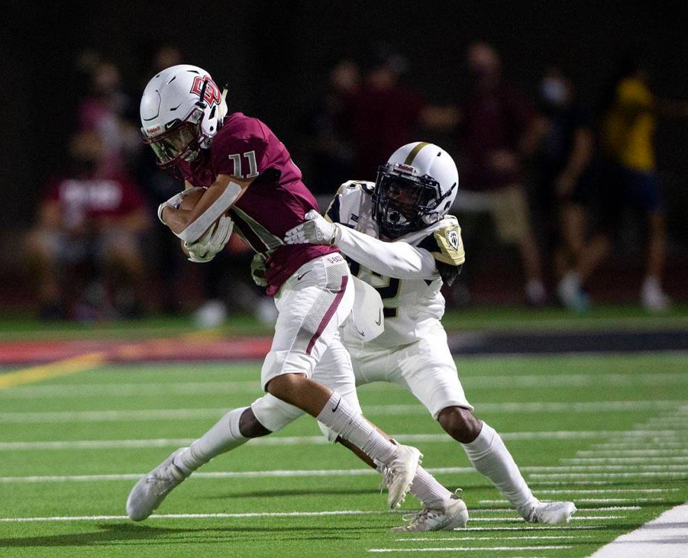 Spring Valley wide receiver Rian Adams (12) takes down Desert Oasis wide receiver Zion Gonsalve ...