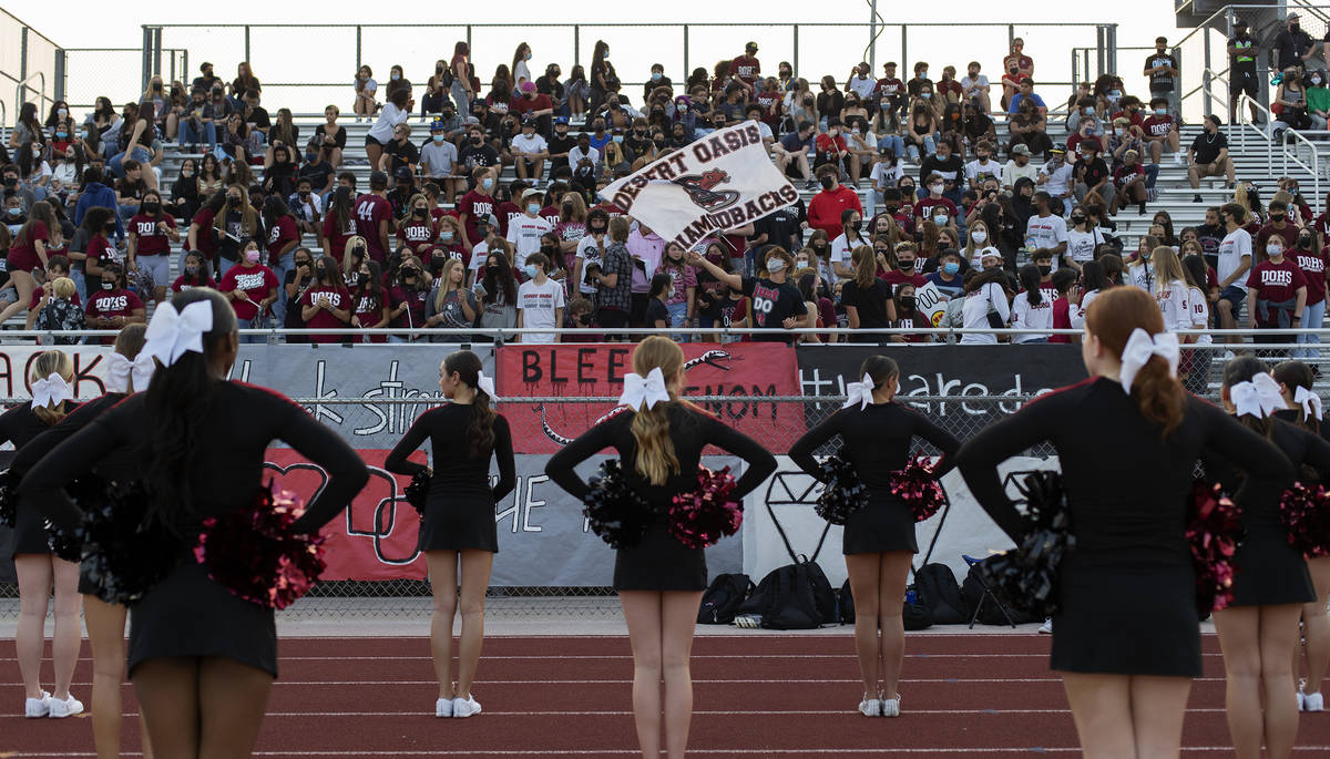 Cheerleaders stand at attention as Desert Oasis fans pack the bleachers during a high school fo ...
