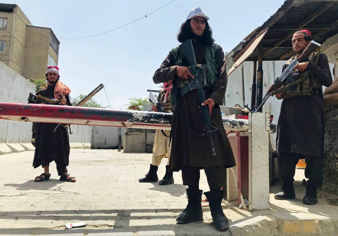 Taliban fighters stand guard at a checkpoint near the US embassy that was previously manned by ...