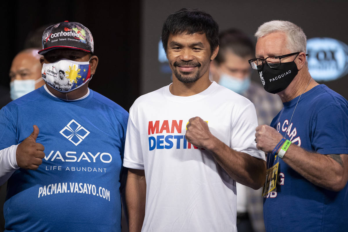 Manny Pacquiao, center, and his trainers Buboy Fernandez, left, and Freddie Roach, pose for a p ...