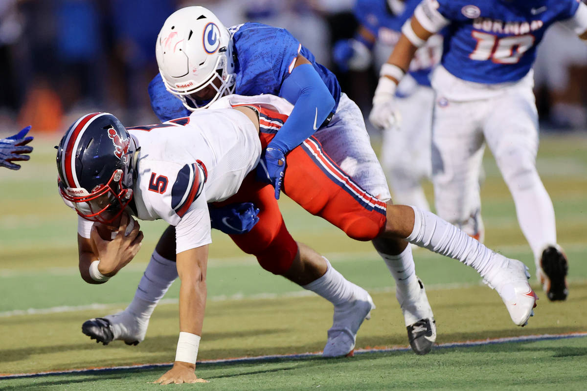 Bishop Gorman's Jamih Otis (26) takes down St. Louis quarterback Alexander Bianco (5) during th ...