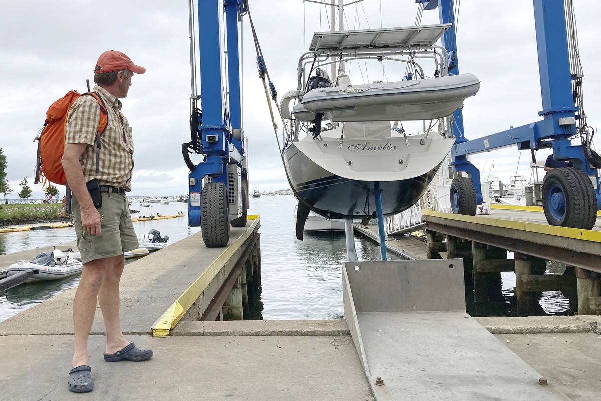 Robin Berthet, of Sheffield, Mass., watches as his sailboat is hauled out of the water onto dry ...