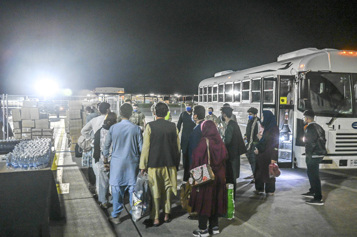 In this image provided by the U.S. Air Force, a group of Afghan evacuees depart a bus at Ramste ...