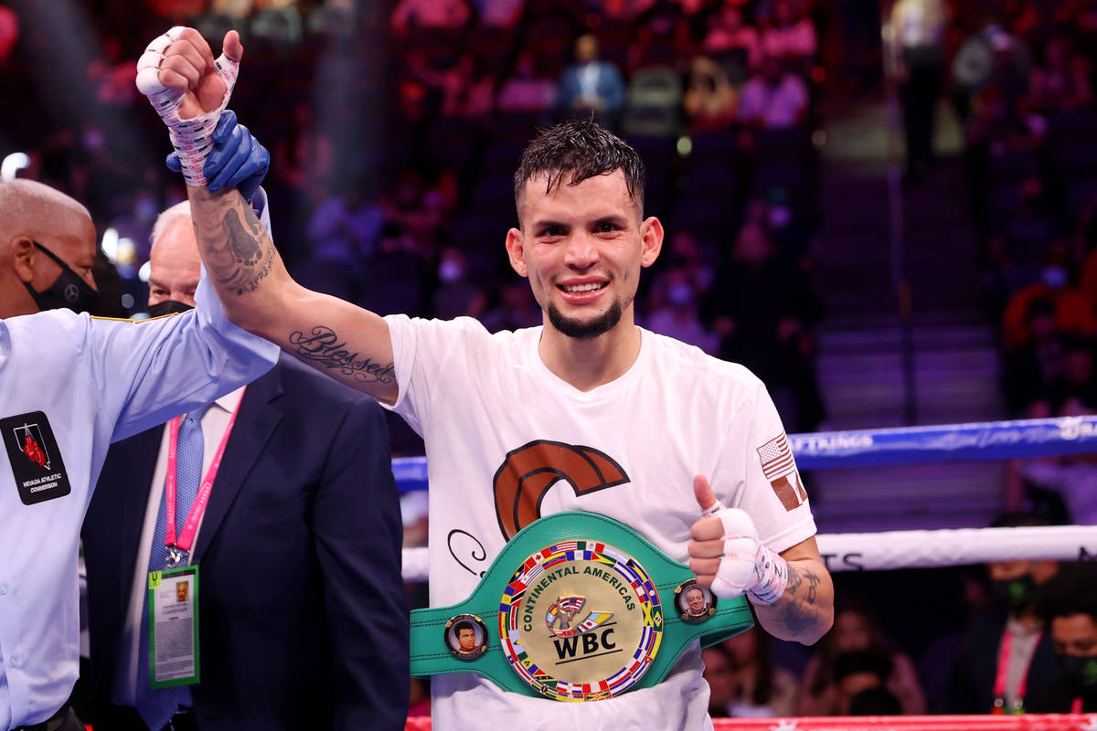 Carlos Castro raises his hands in victory after his knockout win against Oscar Escandon in the ...