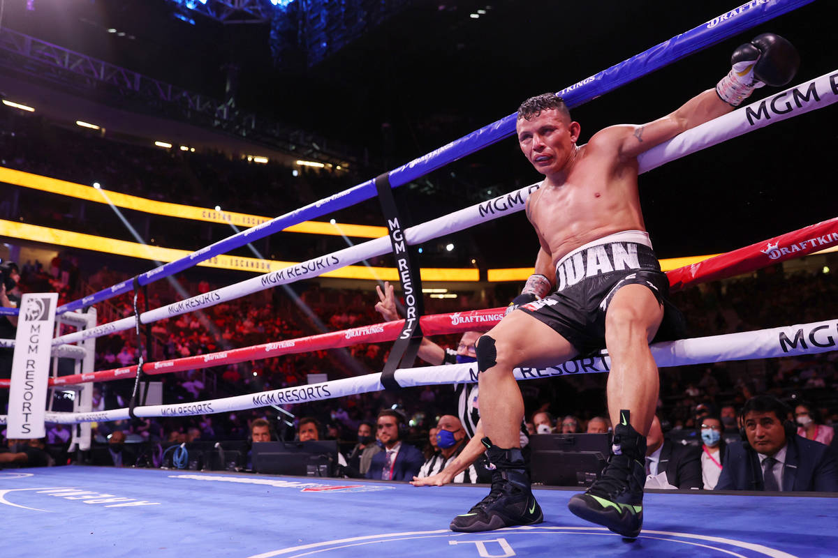 Oscar Escandon hangs to the ropes after getting knocked down by Carlos Castro in the 10th round ...