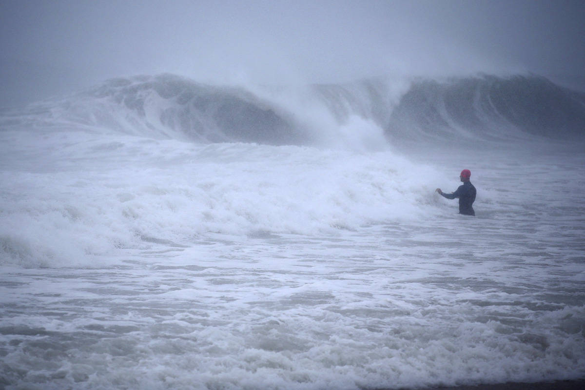 Matt Prue, from Stonington, Conn., walks out into the Atlantic Ocean to body surf the waves fro ...