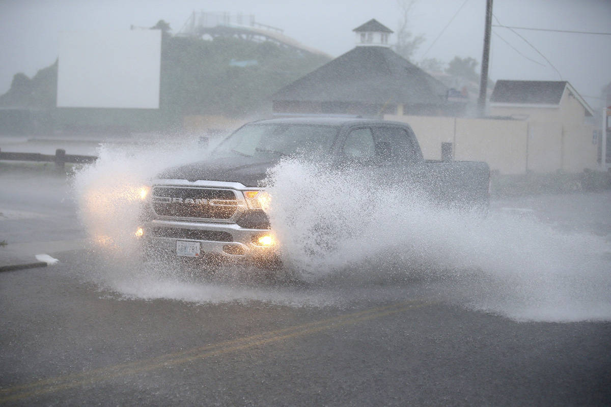 A truck drives through a flooded Atlantic Ave in Westerly, R.I., as Tropical Storm Henri approa ...