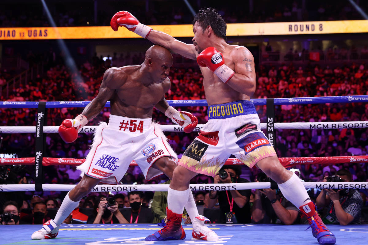 Yordenis Ugas, left, battles Manny Pacquiao in the eight round of the WBA World Welterweight Ti ...